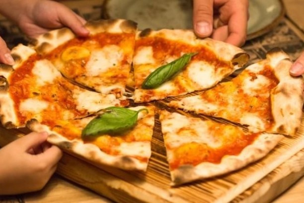 a pizza sitting on top of a wooden cutting board